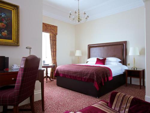 a bedroom with a bed and a desk and a chair at Macdonald Crutherland House in East Kilbride