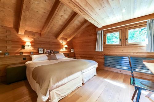 um quarto com uma cama grande num quarto de madeira em Chalet Noemie em Les Houches