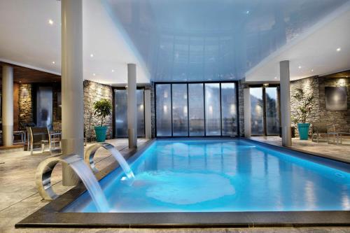 - une grande piscine dans un bâtiment doté de fenêtres dans l'établissement Chalet Noemie, aux Houches