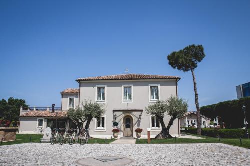 a large white house with bikes in front of it at San Giovanni Relais in San Giovanni in Marignano