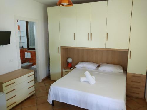 1 dormitorio con 1 cama blanca y armarios blancos en Villa Egusa, en Favignana