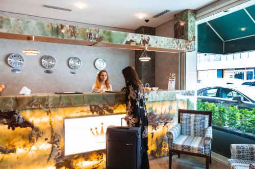 a woman standing behind a counter with a suitcase at Boutique Princess Hotel in Istanbul