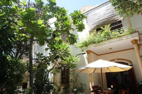 an umbrella in front of a building with trees at Moon house tropical garden - West side in Nha Trang