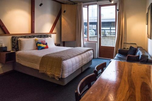 a hotel room with a bed and a wooden table at U Boutique Hotel in Wellington
