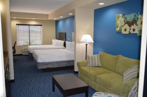 Karnes CityにあるKarnes City Lodgeのベッドとソファ付きのホテルルーム