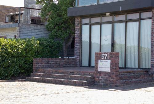 a brick building with a sign in front of a window at Kormorant in Gansbaai