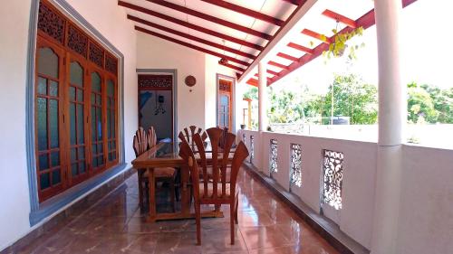 a dining room with a table and chairs on a balcony at Guest House Basilea in Beruwala