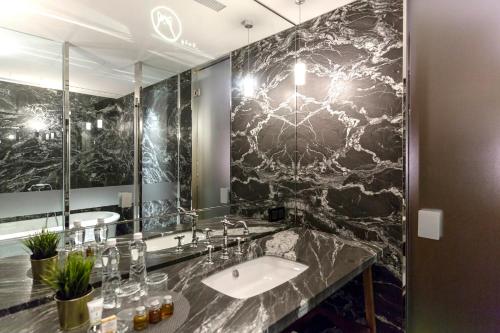 a bathroom with a sink and a large mirror at Inhouse Hotel Grand in Taichung