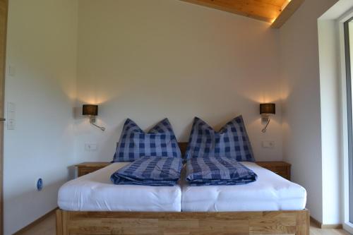 a bedroom with a bed with blue and white pillows at Landhaus Desiree in Hopfgarten im Brixental
