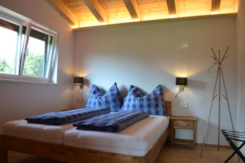 a bedroom with a bed with blue pillows on it at Landhaus Desiree in Hopfgarten im Brixental