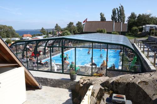 a large swimming pool with people in a building at Sandkaas Family Camping & Cottages in Allinge