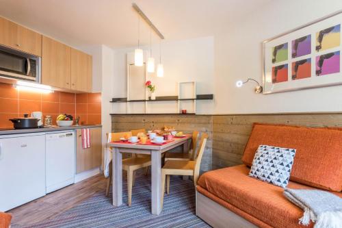 - une cuisine et une salle à manger avec une table et un canapé dans l'établissement Résidence Pierre & Vacances Le Britania, à La Tania