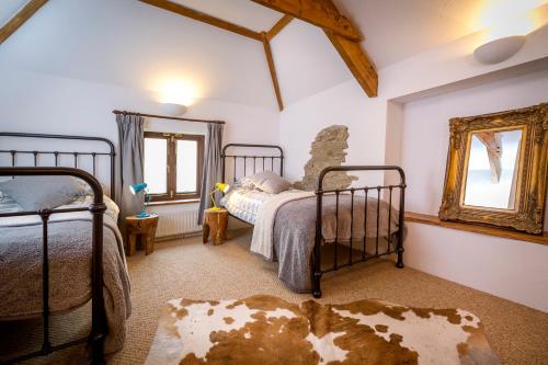 a bedroom with two beds and a mirror at Great Lilly Cottage in Barnstaple