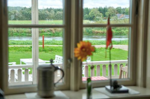 a window looking out at a view of a yard at Svostrup Kro in Silkeborg