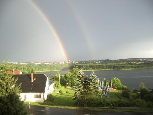 a rainbow over a house and a lake at Pension Seeblick in Quingenberg