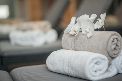 a stack of towels with white flowers on them at Загородный отельно-ресторанный комплекс "Четыре сезона" in Filippovichi