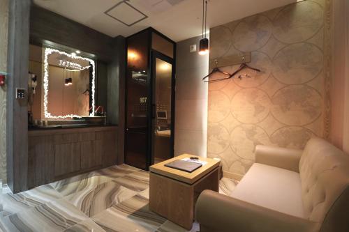a room with a couch and a table and a mirror at Hotel Airport in Busan