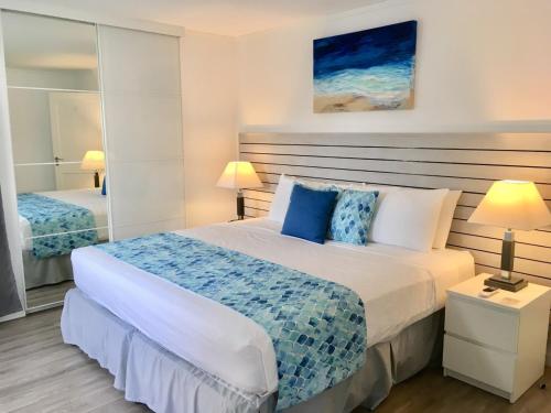 sypialnia z dużym łóżkiem z niebieskimi poduszkami w obiekcie Dover Woods Apartments w mieście Christ Church