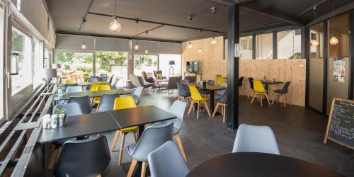 a dining room with tables and yellow chairs at Domaine Long Pre in Stavelot