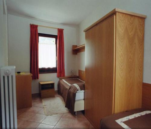 um quarto de hotel com uma cama e uma janela em La Maison de Mémé em Fontainemore