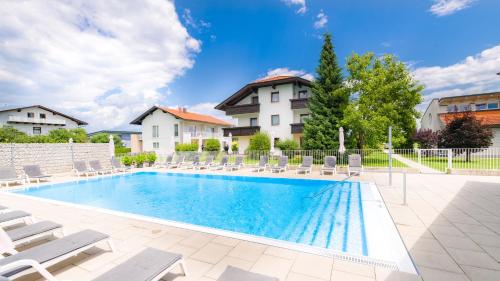 a swimming pool with lounge chairs and a house at Ferienpark Scheiber in Unterburg am Klopeiner See