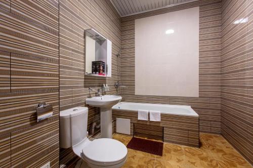 a bathroom with a toilet and a sink and a tub at Korona Hotel in Yoshkar-Ola