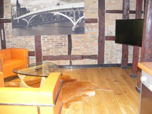 a living room with a glass table and a tv at Amosa Liège City Centre Hotel in Liège