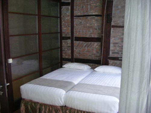 a bed with two pillows in a room at Amosa Liège City Centre Hotel in Liège