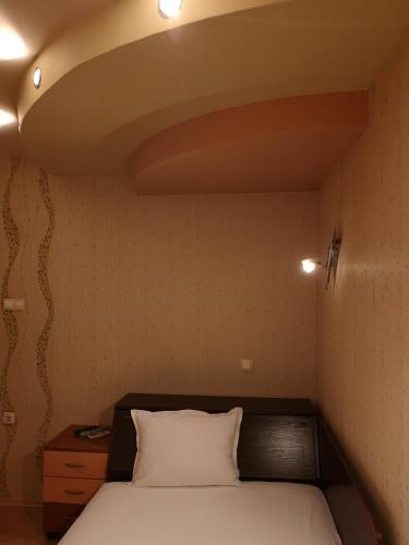 a bedroom with a bed with a white pillow at Стаи за гости "Панега" in Pleven