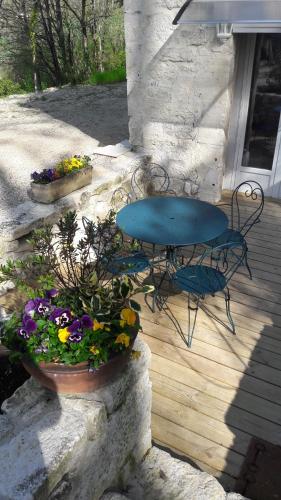 a patio with a table and a table and flowers at Taillefer in Saint Paul de Loubressac