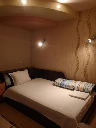 a small bedroom with a bed with white sheets at Стаи за гости "Панега" in Pleven