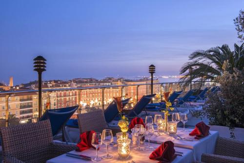 a restaurant with tables and chairs on a balcony at Hotel Aston La Scala in Nice