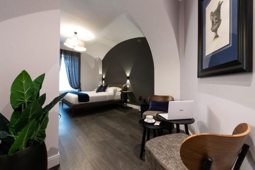 - un salon avec une chambre dotée d'un lit et d'un ordinateur portable dans l'établissement Lungotevere Ripa, à Rome