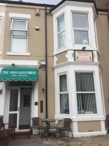 a building with tables and chairs in front of it at The Pines Guest House in Whitley Bay