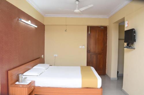 a bedroom with a bed and a flat screen tv at Hotel Surya Residency Majestic in Bengaluru