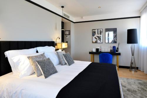 - une chambre avec un grand lit blanc et des oreillers dans l'établissement Hôtel le Touring, à Saint-Raphaël