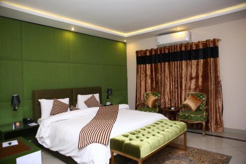 a bedroom with a bed and a green wall at Safari Club 4 in Rawalpindi