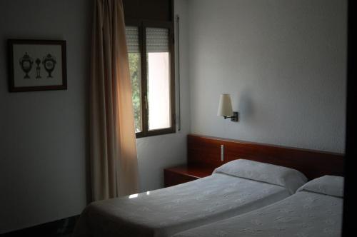 a hotel room with two beds and a window at Hotel Betriu in Coll de Narg&oacute;