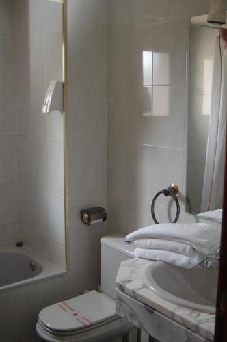 e bagno con lavandino, servizi igienici e vasca. di Hotel Betriu a Coll de Nargó