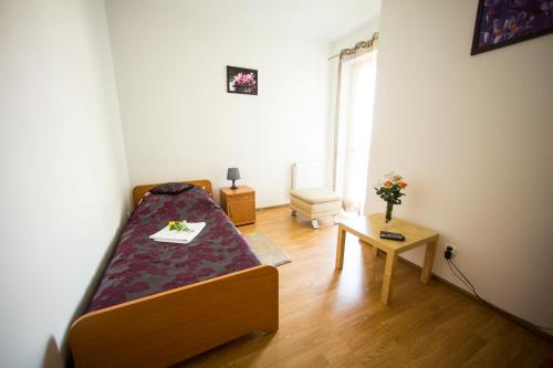 ワルシャワにあるApartamenty Rokoのベッドとテーブル付きの小さな部屋