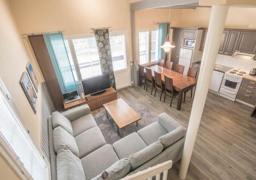 a living room and kitchen with a couch and a table at Levikaira Apartments - Alpine Chalets in Levi