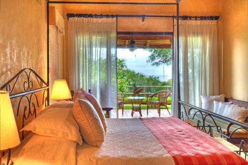 Un dormitorio con una cama grande y un balcón. en Hacienda Barrigona, en Sámara