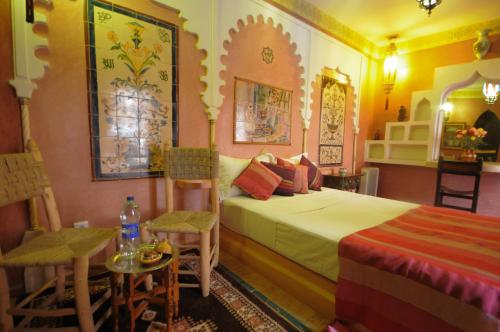 une chambre avec un lit, une table et des chaises dans l'établissement Riad Basma Marrakech, à Marrakech