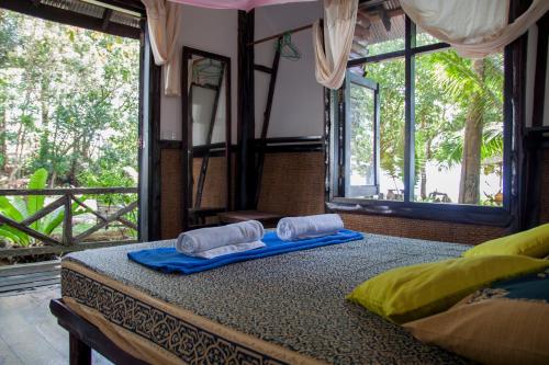 a bedroom with a bed with two towels on it at Ban_na in Ko Chang
