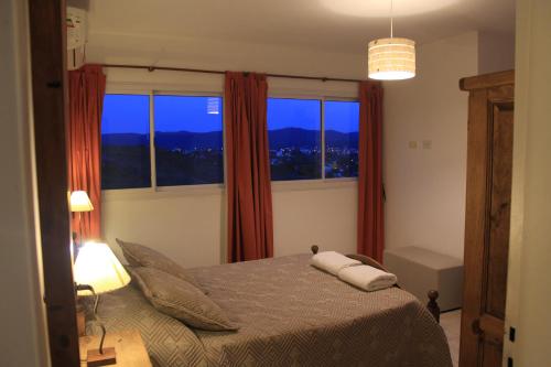 um quarto com uma cama e uma grande janela em Cabañas del Rey em Villa Carlos Paz
