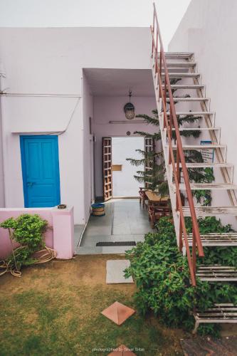a staircase in a house with a blue door at Rajguru guest house in Pushkar