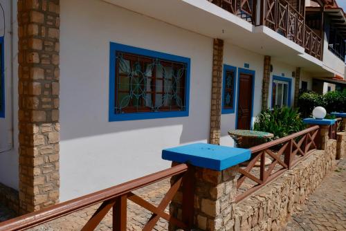 a house with a blue bench on a balcony at Pensão Alcinda Bettencourt 100 meters to the Beachfront in Santa Maria