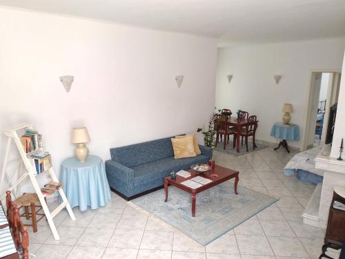 a living room with a blue couch and a table at Seafarer's Suite in Galaxidhion