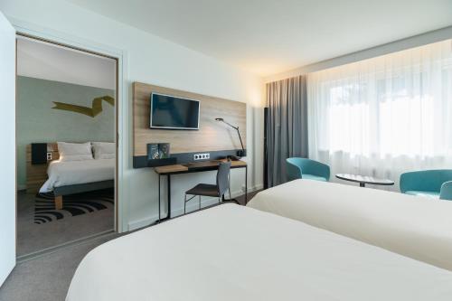 Postel nebo postele na pokoji v ubytování Novotel Wrocław City