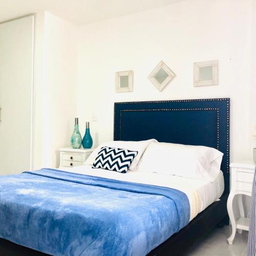 a bedroom with a large bed with a blue headboard at Edificio saintjoseph in Cali